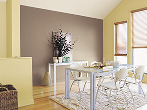 Fresh bright lemon dining room with neutral wall and clean white table and chairs with cosy rug